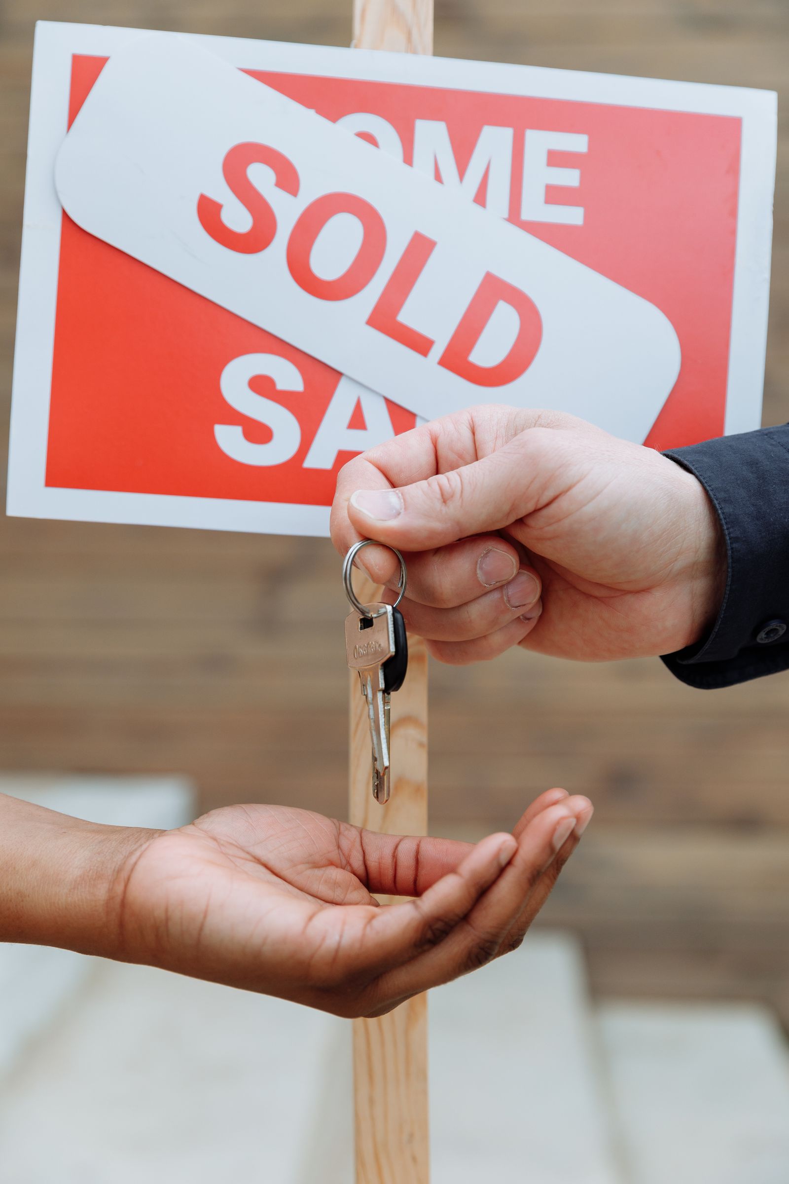 Hands exchanging house keys at the start of a home swap between two families