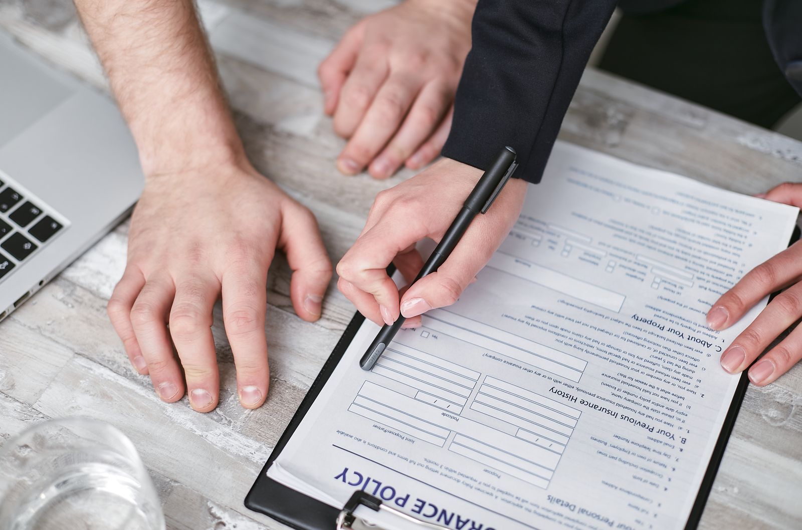 Two people signing the written agreement that completes their home swap insurance