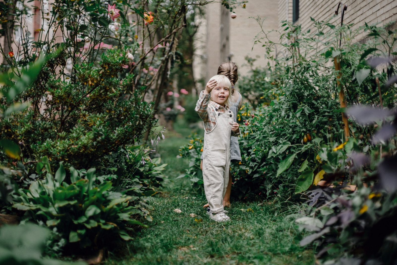 Two children playing in the enclosed garden of a family home during a holiday exchange