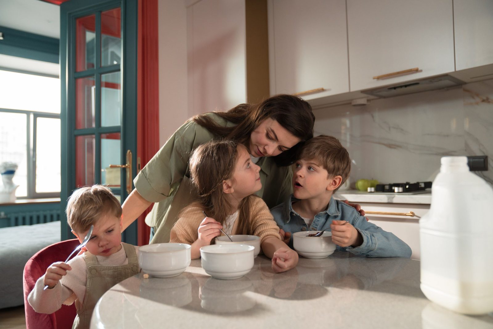 A mother and her three children having breakfast in the kitchen of a home exchange house